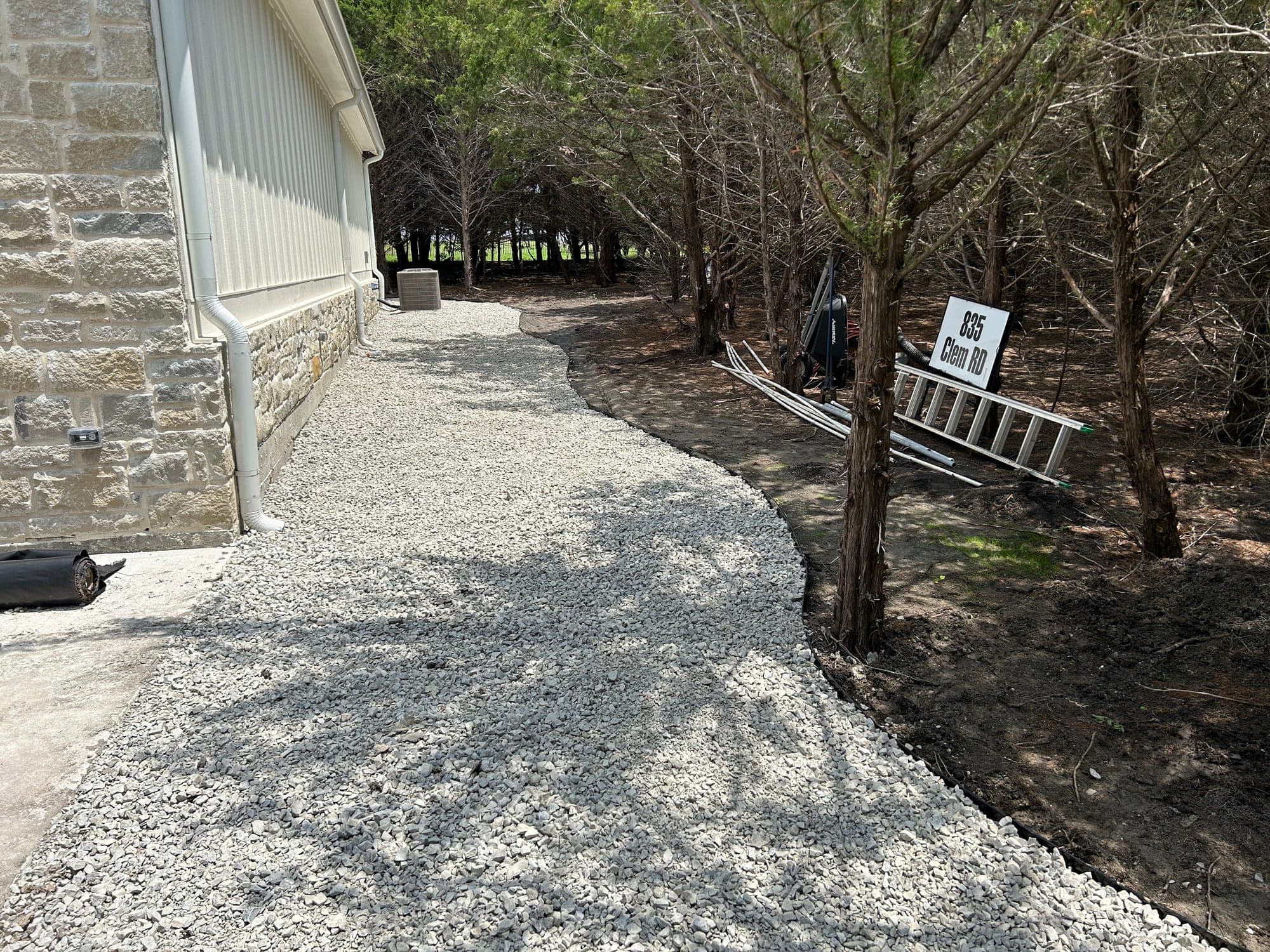 Gravel pathway installed along the side of a home with a clean edge