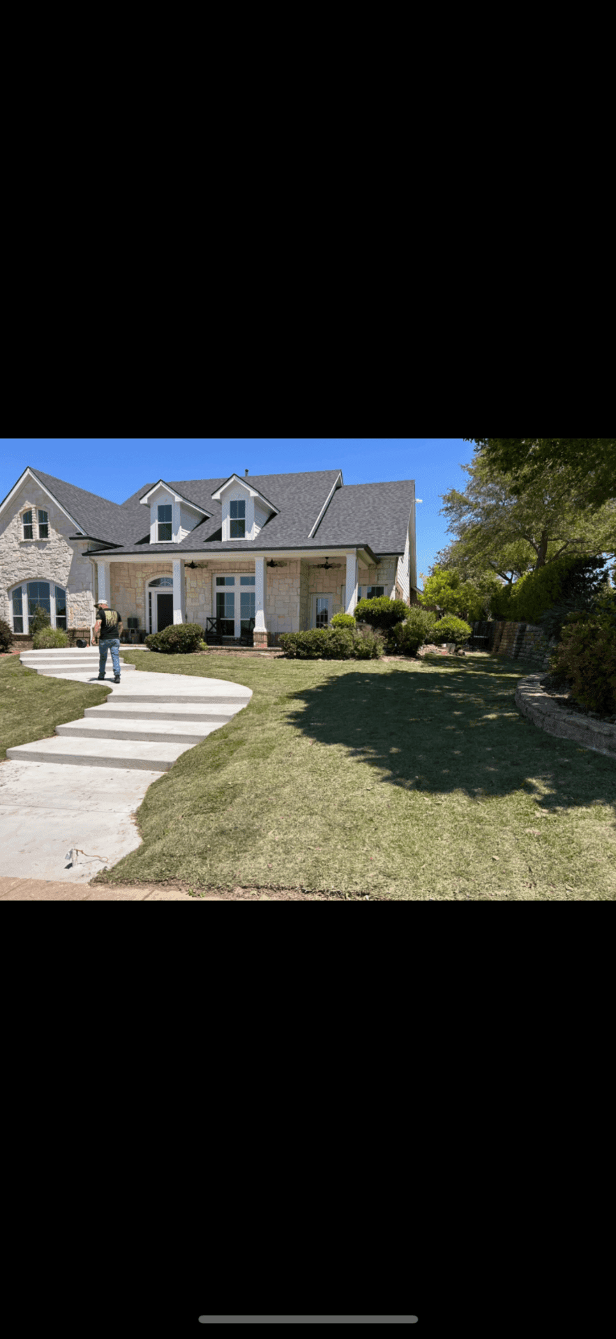 Finished curved concrete walkway with landscape beds at a DFW home