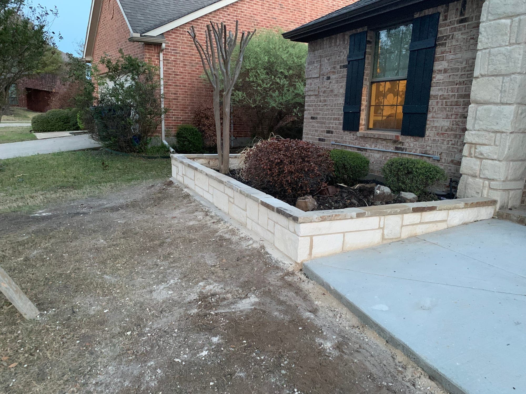 Custom stone planter wall built along a driveway entry for a DFW property